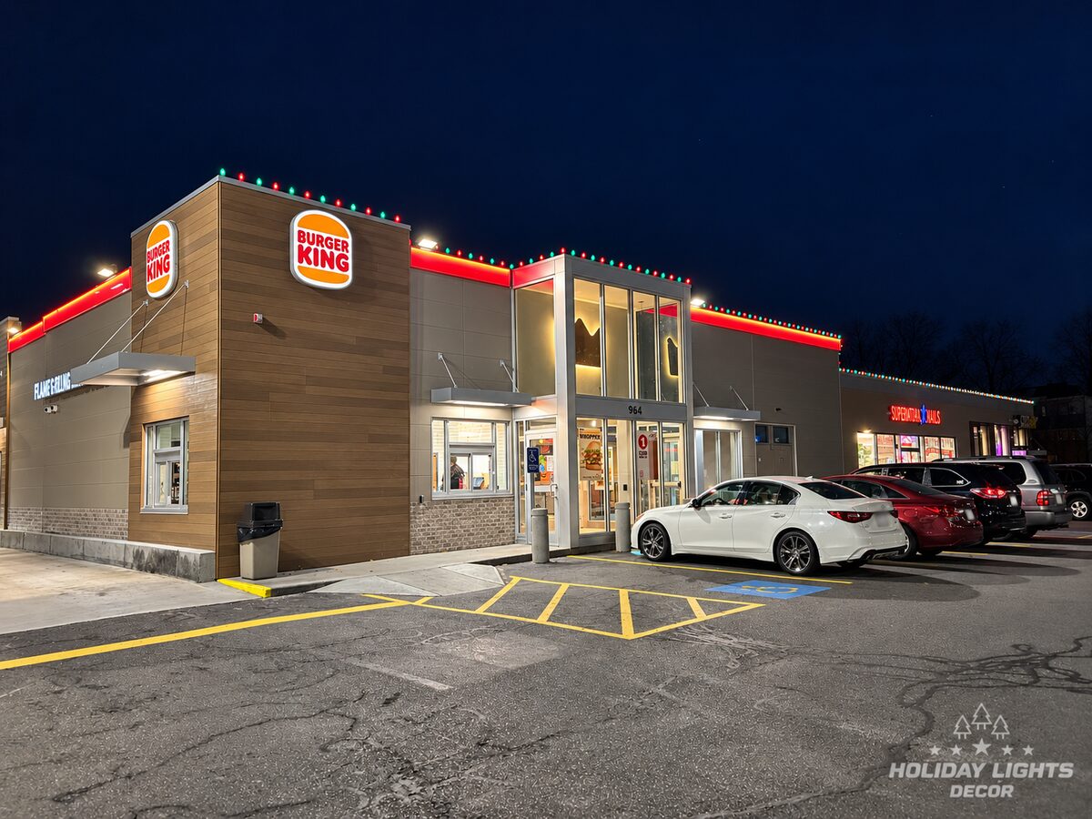 Commercial restaurant facade with red and green roofline lights at night